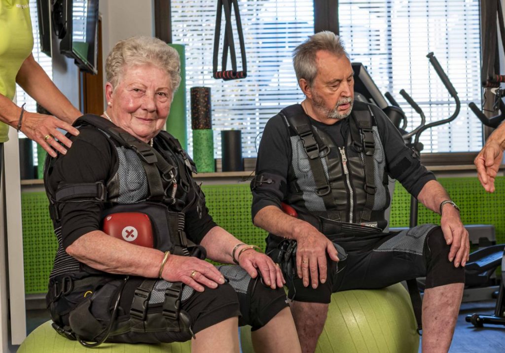 Zwei Senioren sitzen auf grünen Gymnastikbällen und nehmen bei Aktiv Fit Sein in Zirndorf an einem EMS-Training teil.